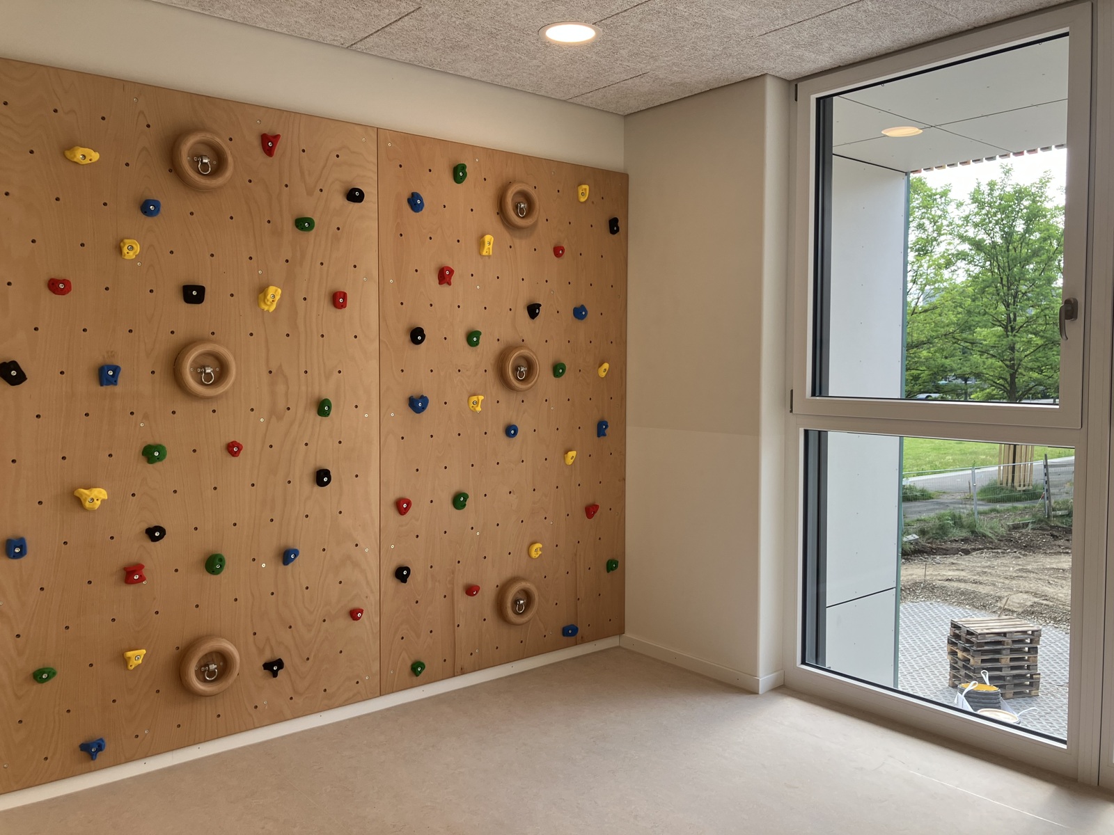 Kletterwand mit bunten Griffen im Bewegungsbereich der Kita am Dülferanger